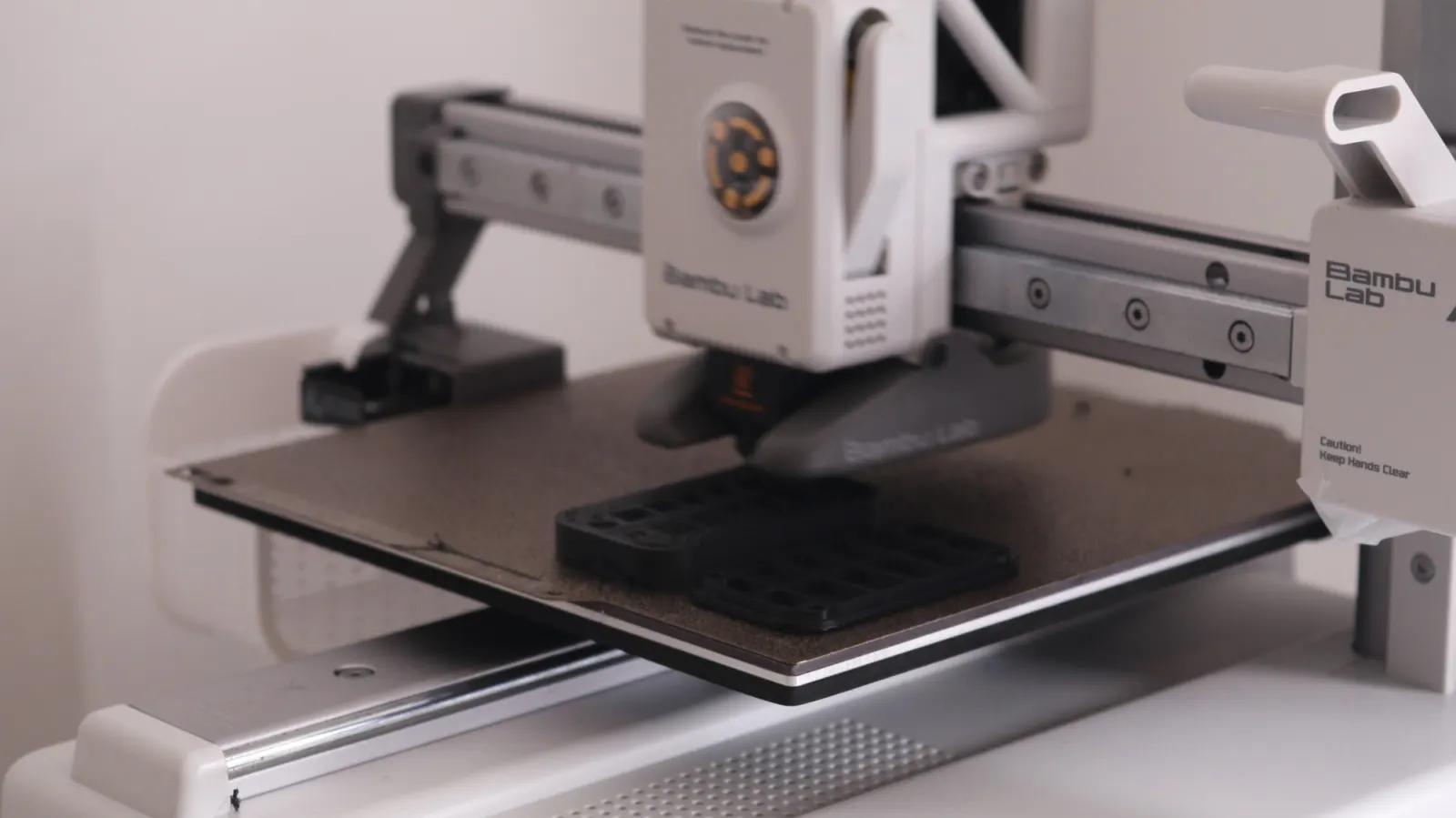 A 3D printer printing a black test part of the tracker housing.