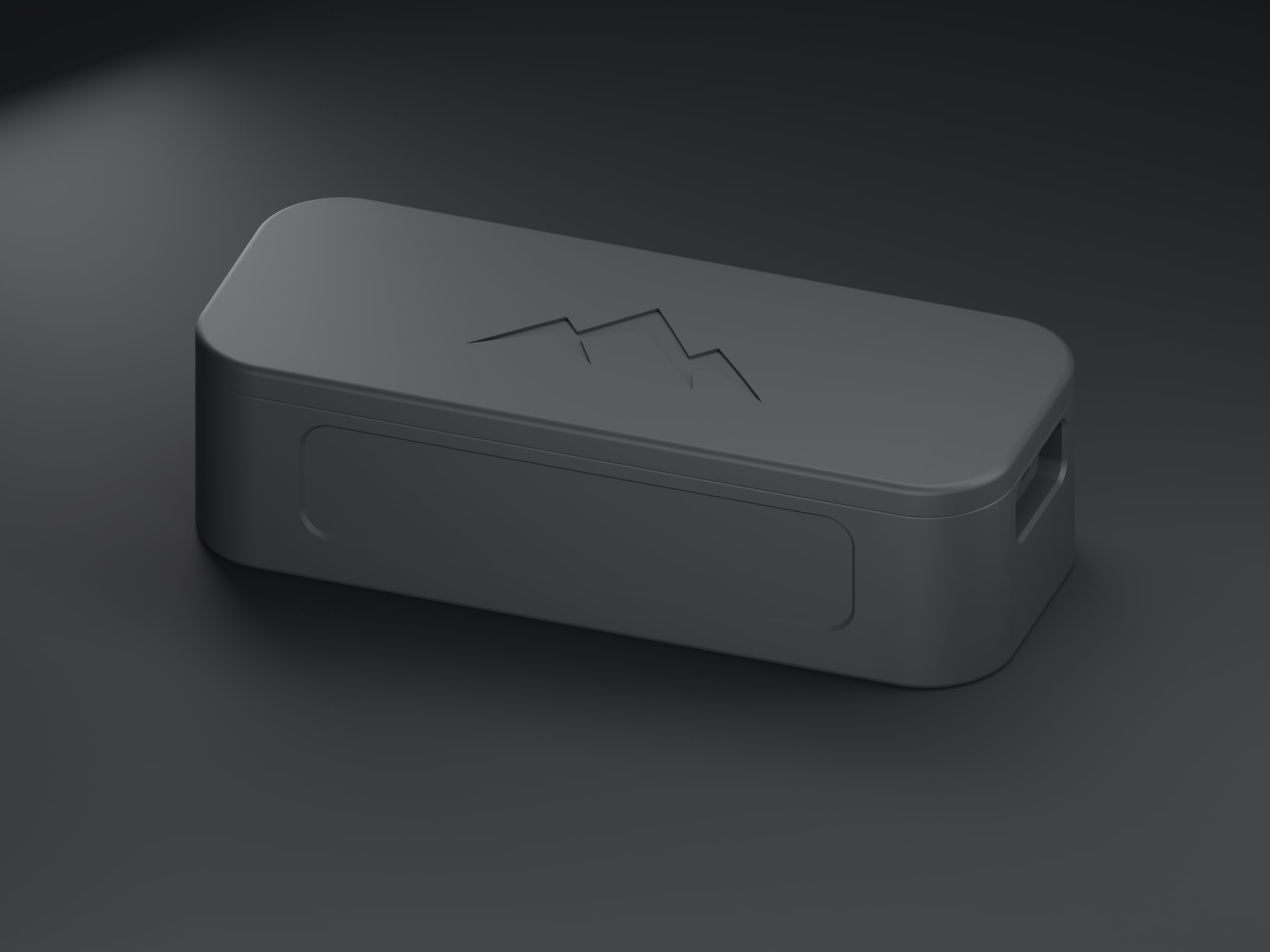 Three-quarter view of the NOMAE enclosure on a dark studio floor, the debossed mountain mark catching the key light